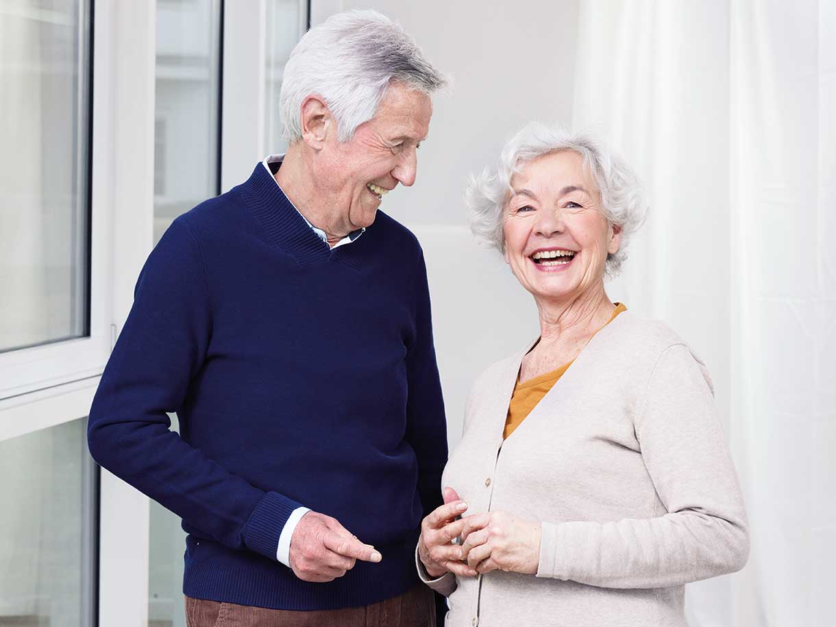 Uśmiechnięty starszy mężczyzna i starsza kobieta stojący razem